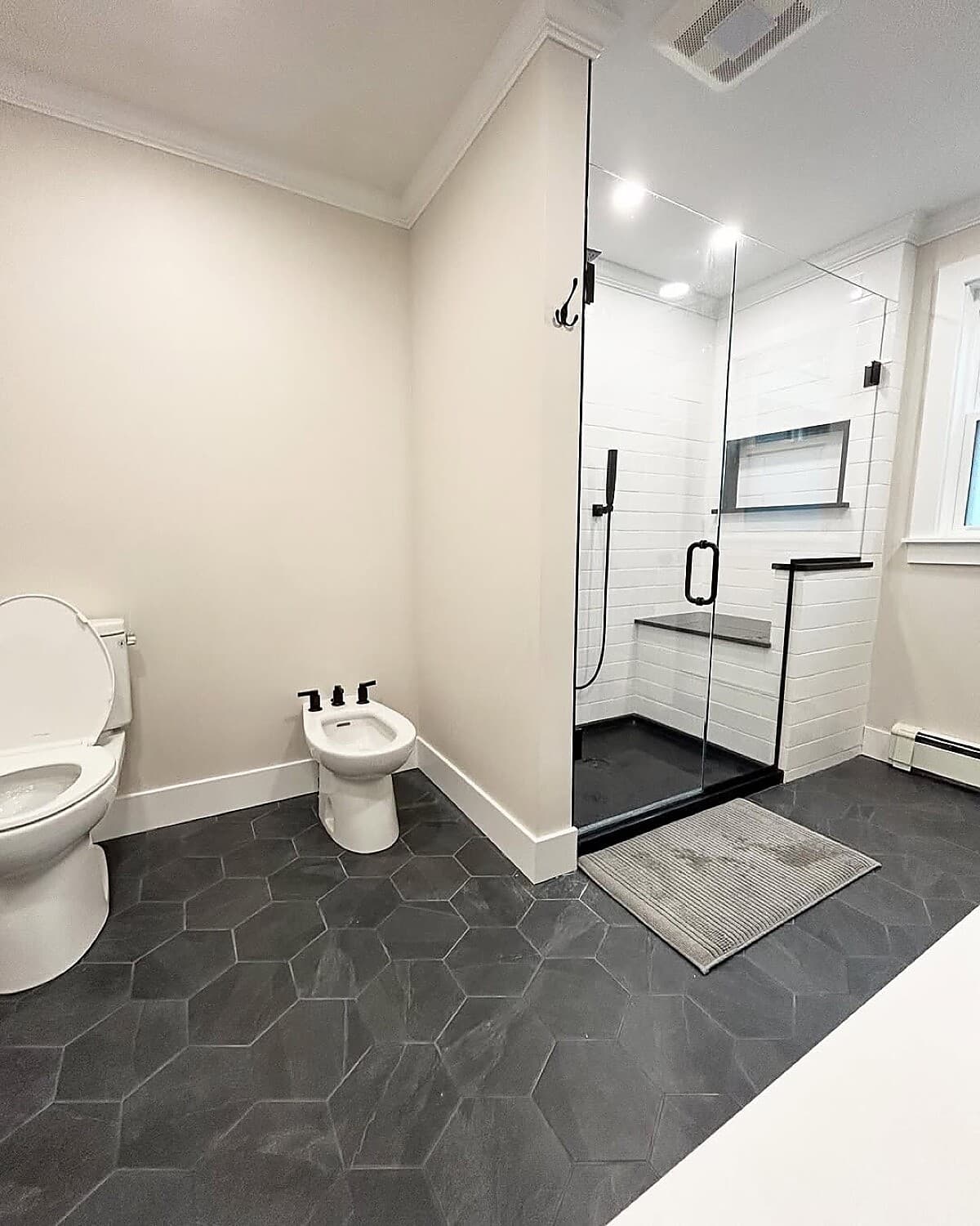 Bathroom with bidet, frameless glass shower, and large format tile