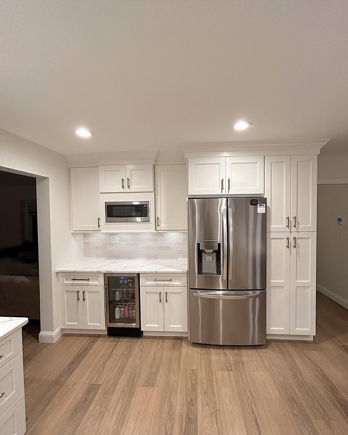 White kitchen with built-in wine fridge and stainless appliances
